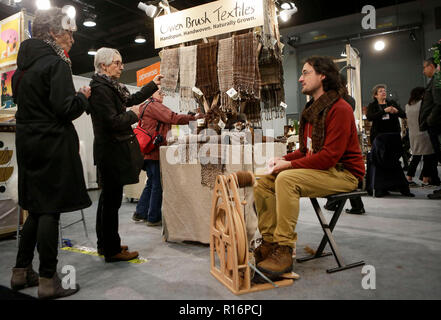 Vancouver, Canada. 9th Nov, 2018. A man talks to visitors about handwoven scarves at the Circle Craft Market, Canada's one of the biggest craftspeople's annual events, in Vancouver, Canada, on Nov. 9, 2018. Credit: Liang Sen/Xinhua/Alamy Live News Stock Photo