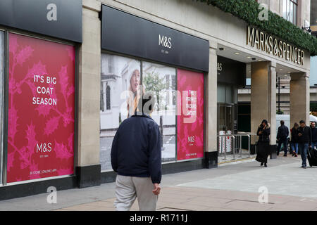 Shoppers are seen outside Marks and Spencer store on London's Oxford Street. The retail sector faces difficulties as consumers cut down on spending and do more of their shopping online. A report by accountancy firm PWC has said that over 1,000 stores disappeared from Britain's top 500 high streets in the first six months of the year. Stock Photo
