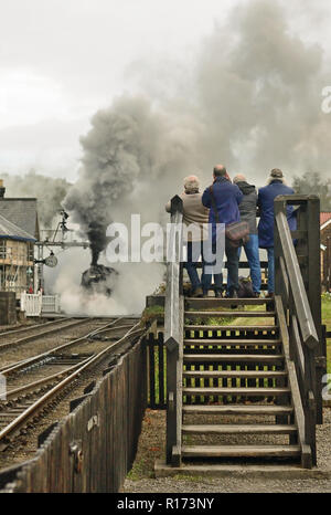 Photographers capture a smoky steam train departure from Grosmont on the North Yorkshire Moors Railway. Stock Photo