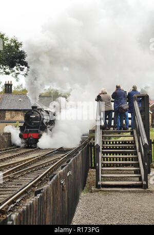 Photographers capture a smoky steam train departure from Grosmont on the North Yorkshire Moors Railway. Stock Photo