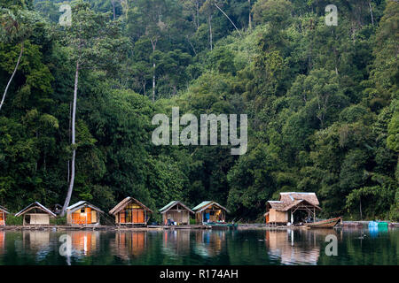 Wooden bungalows on tropical shore in the Chiew Lan Lake, Khao Sok national park, Thailand Stock Photo