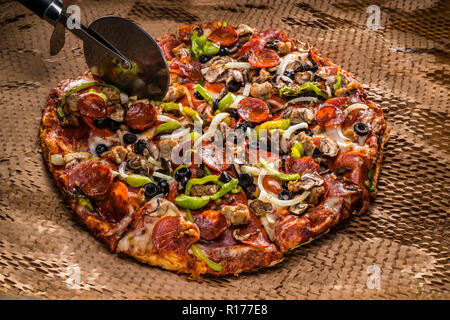 medium pizza with black olives, italian sausage, linguica, mushrooms, onions, peppers, salami, pepperoni Stock Photo