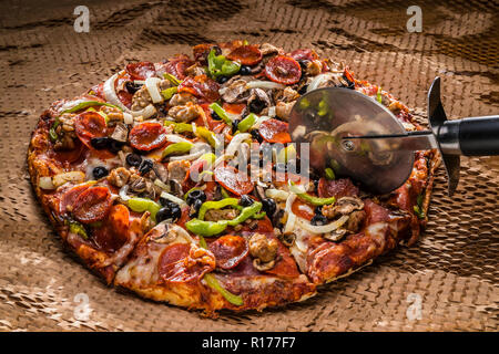 medium pizza with black olives, italian sausage, linguica, mushrooms, onions, peppers, salami, pepperoni Stock Photo