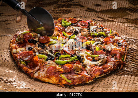 medium pizza with black olives, italian sausage, linguica, mushrooms, onions, peppers, salami, pepperoni Stock Photo