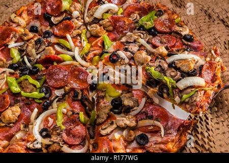 medium pizza with black olives, italian sausage, linguica, mushrooms, onions, peppers, salami, pepperoni Stock Photo