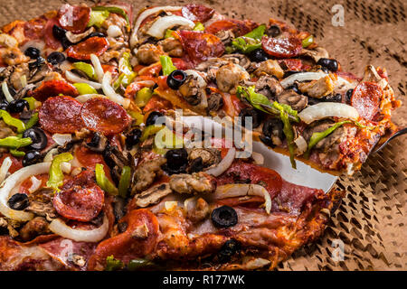 medium pizza with black olives, italian sausage, linguica, mushrooms, onions, peppers, salami, pepperoni Stock Photo