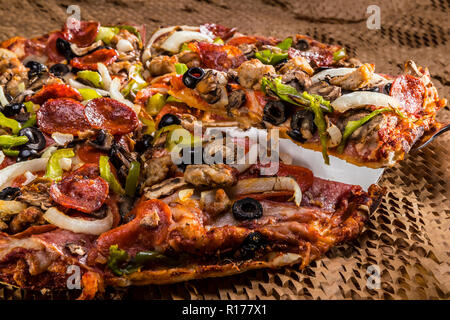 medium pizza with black olives, italian sausage, linguica, mushrooms, onions, peppers, salami, pepperoni Stock Photo