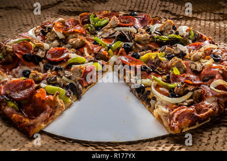 medium pizza with black olives, italian sausage, linguica, mushrooms, onions, peppers, salami, pepperoni Stock Photo