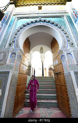 A Moroccan woman exiting a mosque in the old city of Fes. Stock Photo