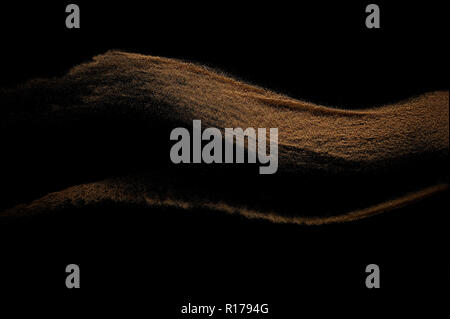 Sandy wave isolated on black background. Abstract sand dune. Stock Photo