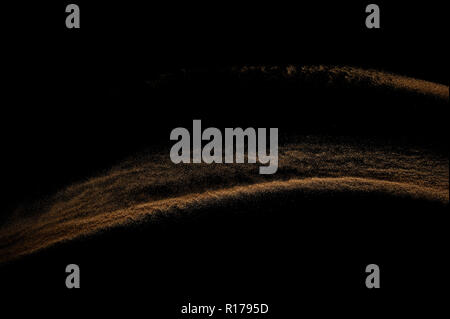 Sandy wave isolated on black background. Abstract sand dune. Stock Photo
