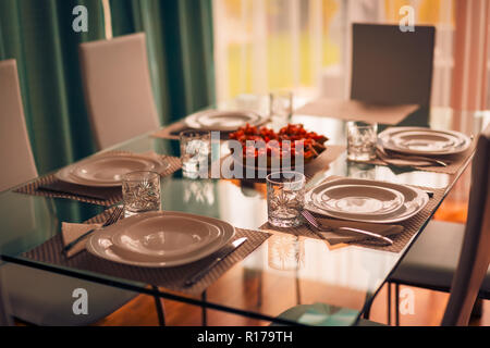 Italian dinner table with cutlery, plate, glass, napkins and naperies with salt and pepper on the table. Elegant home dinning room Stock Photo