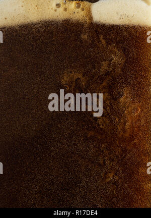 Frothy draught guinness/dark beer being poured, close up detail Stock Photo