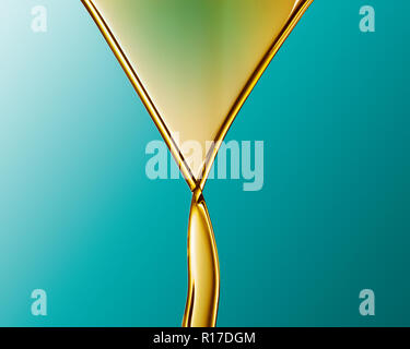 Golden coloured oil flowing into V shape and crossing over against blue background Stock Photo