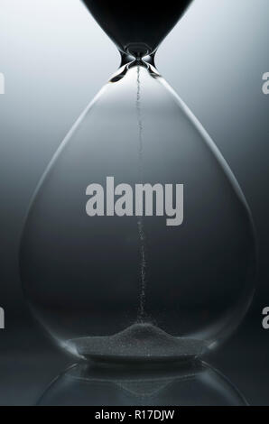 Traditional hourglass egg timer with grains of sand in bottom half showing the beginning of time, studio shot, close up detail Stock Photo