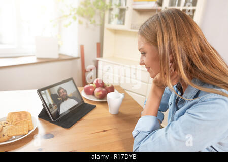 Woman talking with man through a video chat using a digital tablet Stock Photo