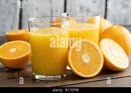 Two glasses  of orange juice with oranges  on wooden table Stock Photo