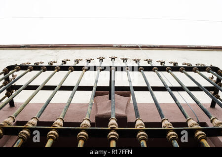 close-up of bars on an old window, purple colors with beige and white, background of an abandoned old house, architectural abstract background. Stock Photo