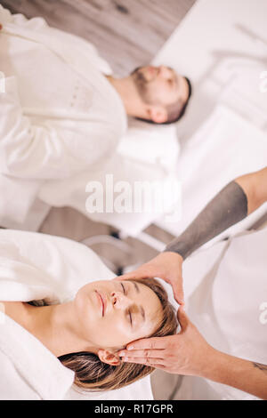 doctor caring woman's sore head , sleeping beaded man on the background of the photo Stock Photo