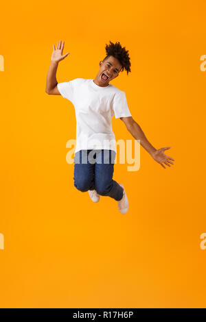 Image of happy young african man jumping isolated over yellow background. Stock Photo