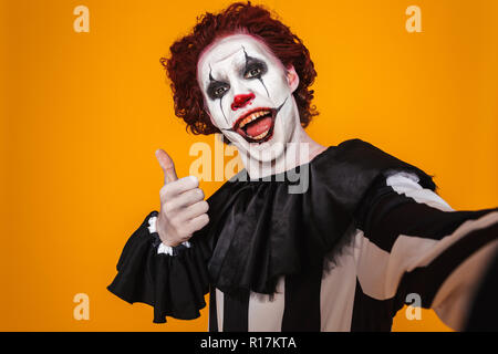 butiksindehaveren Frisør Ødelæggelse Excited clown man 20s wearing black costume and halloween makeup looking at  camera isolated over yellow background Stock Photo - Alamy