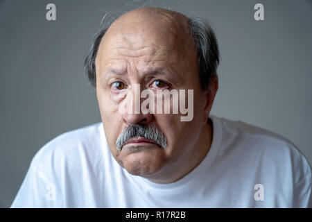 Portrait of older adult senior man in pain with sad and exhausted face in human emotions facial expression retirement and depression concept isolated  Stock Photo