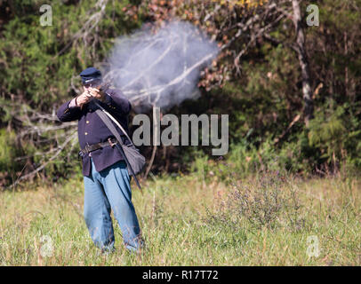 MCCONNELLS, SC (USA) - November 3, 2018:  Reenactor in a Union uniform fires a rifle in a recreation of the American Civil War. Stock Photo