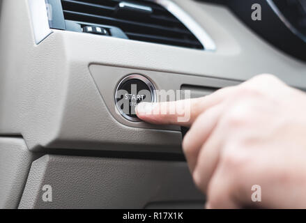 Car start stop system with finger pressing the button, horizontal image Stock Photo