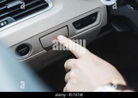 Hand pulling and pushing electric handbrake, Modern car interior. Stock Photo