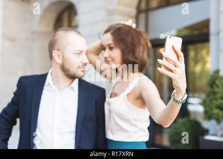 Elegant business couple sitting with phone and book at the waiting hall in the airport. Business travel concept Stock Photo