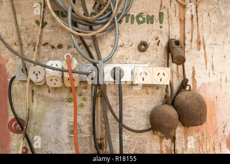 An Australian electrical power board with multiple plugs and leads attached and hanging on a wall in a workshop Stock Photo