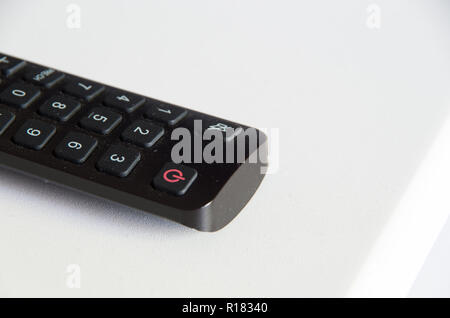 TV Remote on a white background with the power button in focus Stock Photo