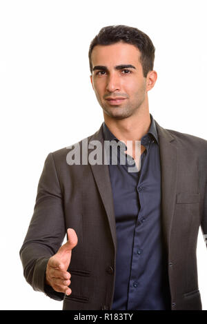 Portrait of young handsome Persian businessman giving handshake Stock Photo