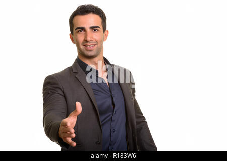 Portrait of young handsome Persian businessman giving handshake Stock Photo