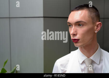 Young androgynous homosexual LGTB businessman thinking outdoors Stock Photo