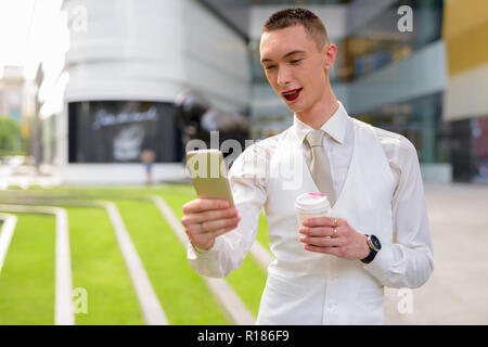 Young androgynous homosexual LGTB businessman using phone Stock Photo