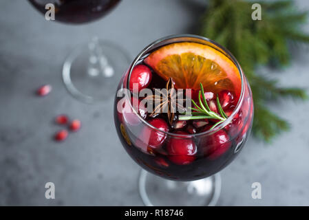 Christmas sangria with oranges, pomegranate seeds, cranberry, rosemary and spices - homemade festive drink mulled wine for Christmas time. Stock Photo
