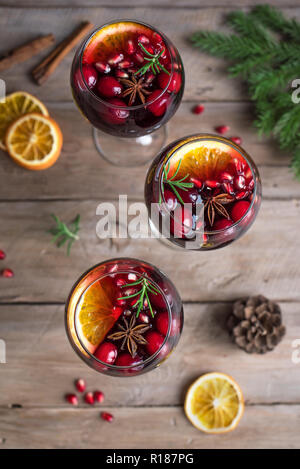Christmas sangria or Mulled wine with oranges, pomegranate seeds, cranberry, rosemary and spices - homemade festive drink for Christmas time. Stock Photo