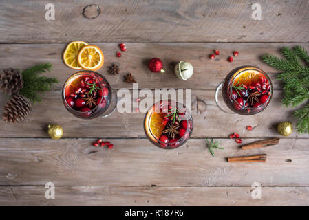 Christmas sangria or Mulled wine with oranges, pomegranate seeds, cranberry, rosemary and spices - homemade festive drink for Christmas time. Stock Photo