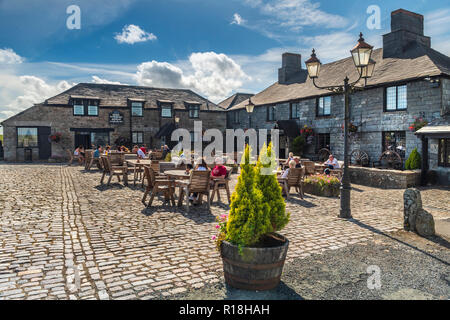 On a sunny day in August, people sit outside Jamaica Inn situated on Bodmin Moor, made famous by Daphne du Maurier in her novel of the same name. Stock Photo