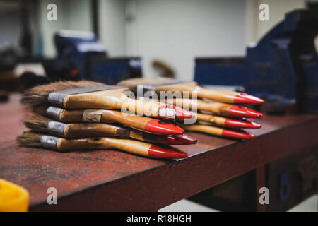 Bunch of paint brush on metal file workbench used to sweep out metal dust after completing the work Stock Photo