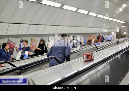 London, England, United Kingdom. At lest one person elects to make the long walk up the stairs while others ride the escalators. Stock Photo