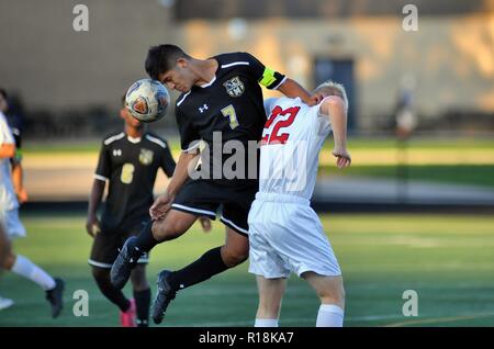 Player executing a header over while pushing off an opponent. USA. Stock Photo