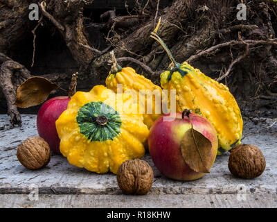 A group of ripe, autumn vegetables and fruits on the rough background. Pumpkins, apples and walnuts next to each other. Stock Photo