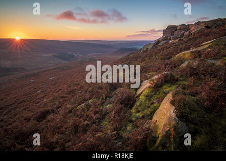 The sun rises over the Peak District, viewed from the Eastern side of Higgar Tor, looking down Burbage Valley to Carl Wark. Stock Photo