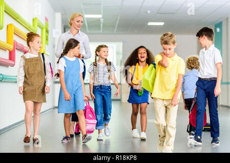 group of happy classmates walking by school corridor Stock Photo