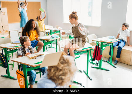 group of schoolchildren having fun at classroom during break Stock Photo