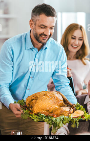 happy young man serving turkey on thanksgiving table Stock Photo