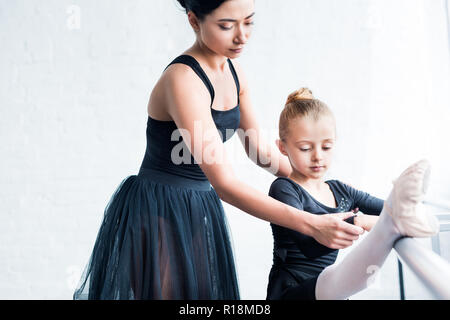 cropped shot of young ballet teacher training child in ballet school Stock Photo