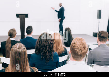 selective focus of african american lecturer talking to audience during seminar in conference hall Stock Photo